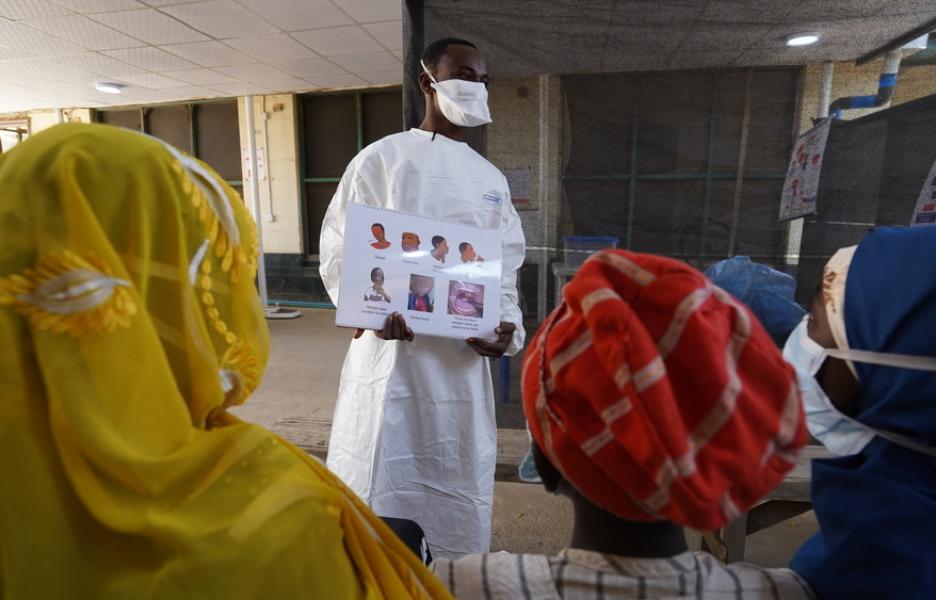 Los pacientes reciben educación sanitaria sobre la prevención y el control de la difteria por parte de un agente de promoción de la salud.