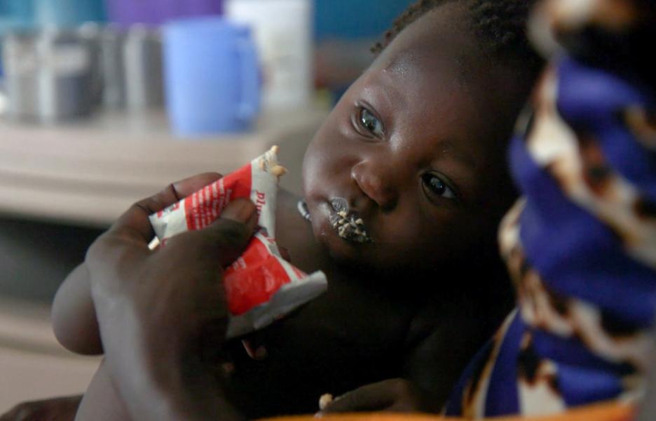 Un niño que padece desnutrición toma un sobre del alimento terapéutico Plumpy Nut en la clínica de MSF en Pibor, Sudán del Sur.