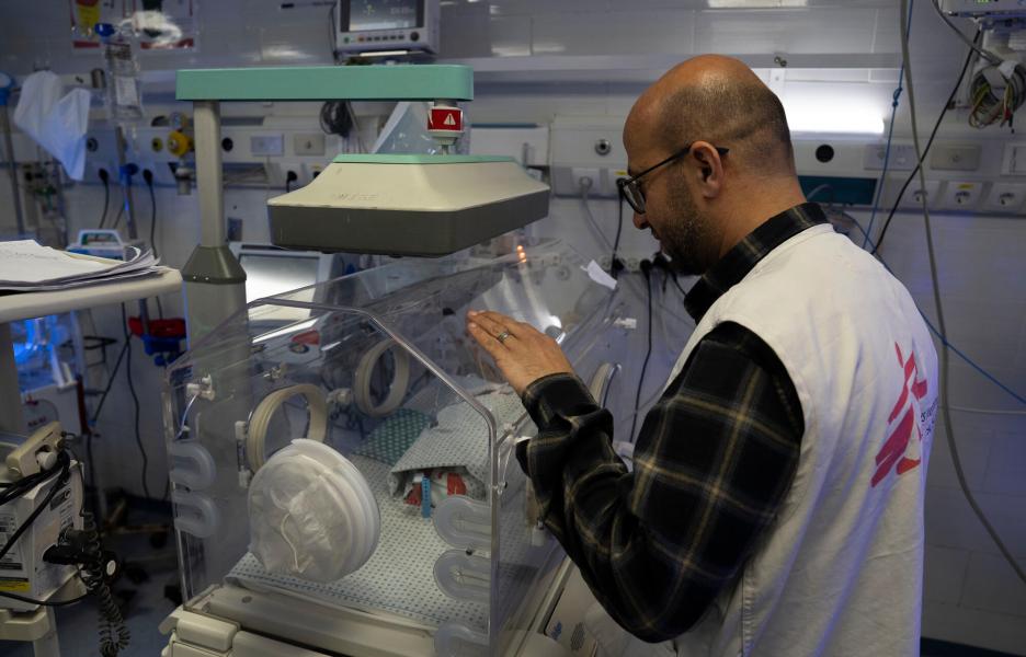Mohammed Shehada, jefe de nuestras actividades de enfermería en el hospital Al Helou, de Gaza, examina a un recién nacido con bajo peso que yace en una incubadora. 
