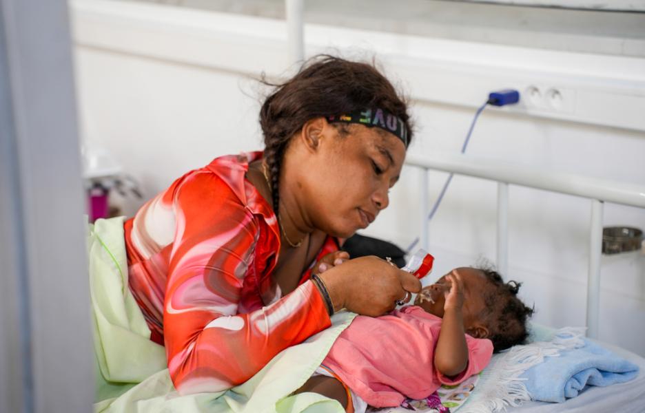 En la sala de pediatría del hospital de Cité Soleil, Jacqueline alimenta a su bebé con un alimento terapéutico