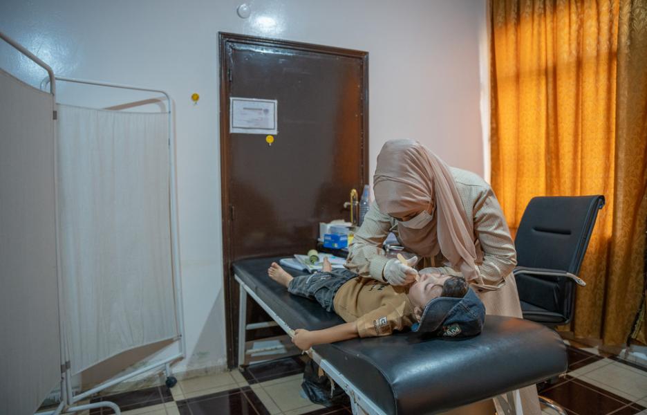 Una médico de la Dirección General de Salud examina a un niño en el centro de atención primaria de Darat Ezza.