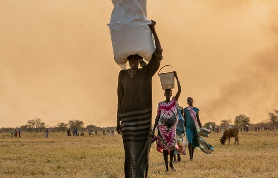 Una mujer lleva bolsas de comida en la cabeza tras un lanzamiento aéreo del PMA cerca de Chuil, en el estado de Jonglei, Sudán del Sur.