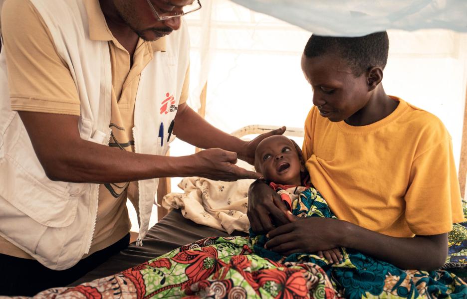 Un médico de MSF examina a Imani, de 9 meses, que ha sido ingresada en la unidad de alimentación terapéutica intensiva por desnutrición aguda grave en el centro de salud de MSF del campo de personas desplazadas de Plaine Savo