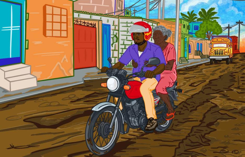 Una persona viaja en una moto taxi por las calles de Puerto Príncipe.