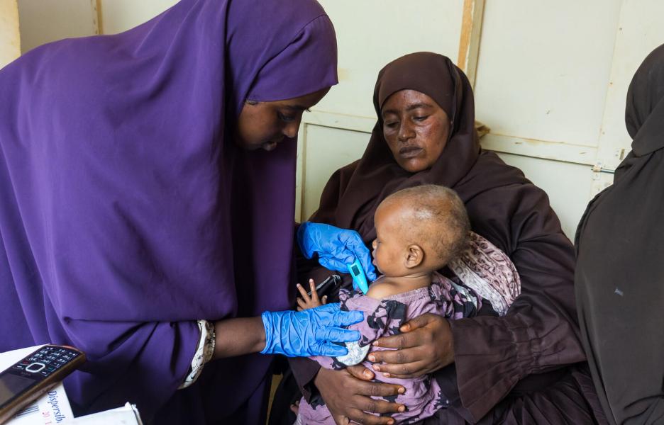 La enfermera Hawa Hassan toma la temperatura a un niño en el puesto de salud de Farboor.