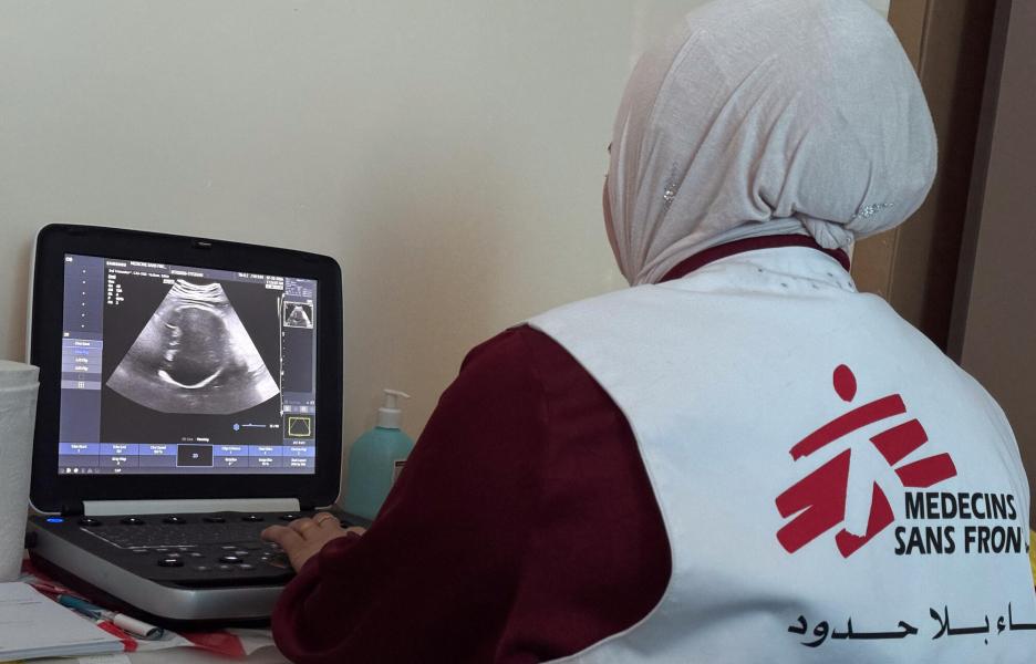 Una trabajadora de MSF revisa la ecografía de un paciente durante una consulta móvil en Khallet Al Mai, Hebrón, Cisjordania.