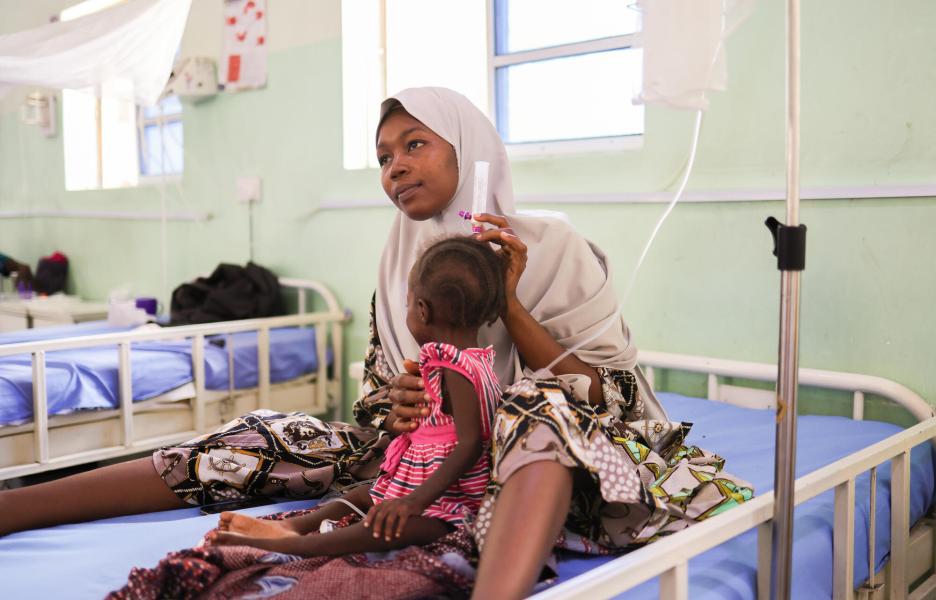 Mariya Mukthar alimenta a su hija Murjanatu Mamman, de 22 meses, con leche terapéutica a través de una sonda nasogástrica.