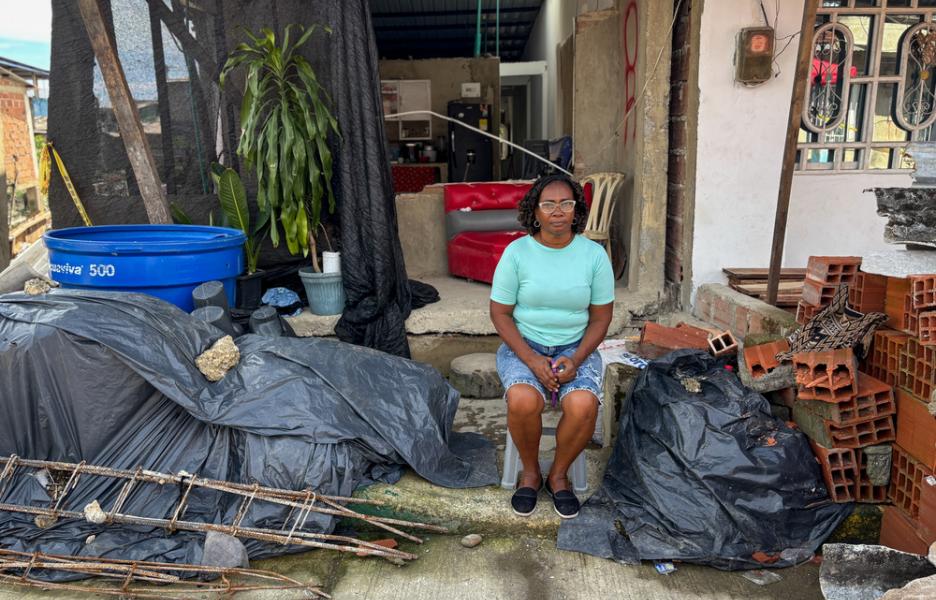 Sonia Hernández está sentada sobre lo que antes era la fachada de su casa, que tuvo que ser demolida después de que el terremoto la dejara completamente agrietada.