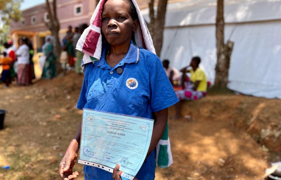 Esther Piurac recibe el alta del centro de tratamiento de ébola de MSF en Bambu tras recuperarse de la enfermedad del ébola. Sostiene en la mano su certificado de recuperación.