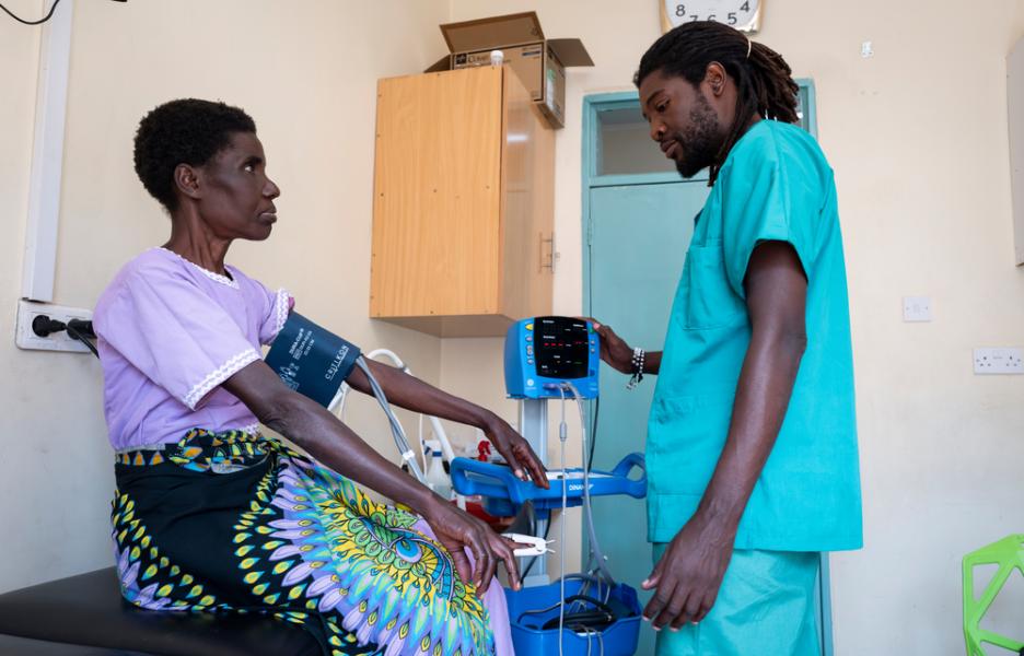 Christopher Chalunda, enfermero de cuidados paliativos de MSF, toma la tensión arterial a Lucy Nchoma, de 60 años.