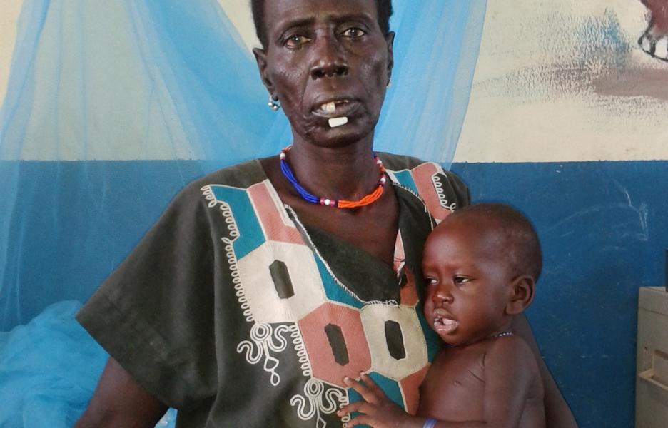 La pequeña Nyuruth Gain Nyandit, de 1 año, junto a su abuela, en nuestro centro de desnutrición terapéutica de Pibor, en Sudán del Sur.