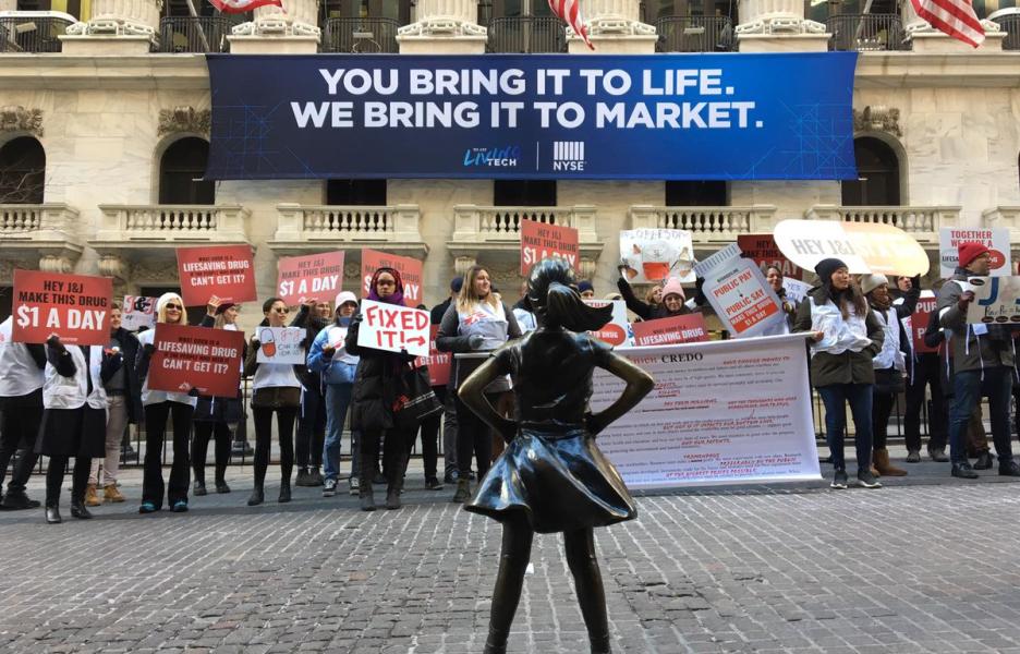 Nuestros compañeros protestan frente a la Bolsa de Nueva York por el precio de un medicamento de JNJ vital para tratar la tuberculosis. Nuestros compañeros protestan frente a la Bolsa de Nueva York por el precio de un medicamento de JNJ vital para tratar la tuberculosis.