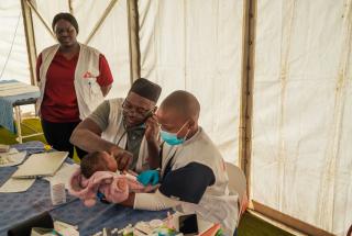 La consejera Nosisipho Zozi observa mientras el doctor Adebayo Mikail Abisola y la enfermera Silindelwe Khanyile atienden a un joven paciente en Musina, cuya familia huyó de los disturbios contra los inmigrantes en Sudáfrica.