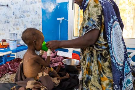 Una madre alimenta a su hijo con desnutrición grave con leche terapéutica en el Centro de Alimentación Terapéutica para Pacientes Hospitalizados (ITFC) del Hospital Regional Bay, apoyado por MSF en Baidoa, Somalia. © Yahya Mohammed/MSF
