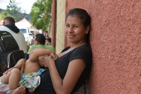 La hija mayor de la familia Brito amamanta a su hijo mientras espera que su familia reciba consulta médica.