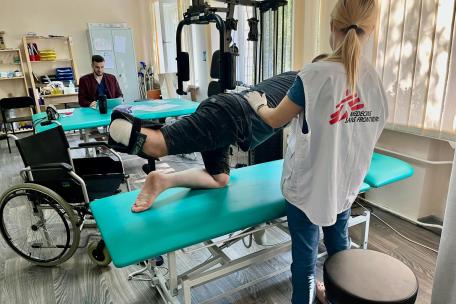 MSF physiotherapist with war-wounded patient