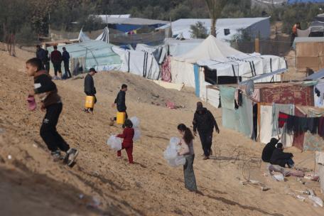 Palestinos desplazados llevan botellas vacías a un camión de agua de MSF en Tal Al-Sultan, un barrio de Rafah.