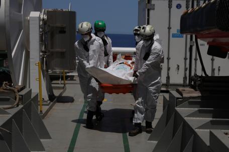 Traslado de uno de los cuerpos recuperados por el Geo Barents a una patrullera de la Guardia Costera italiana cerca de Lampedusa.