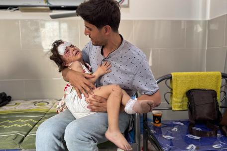 Julia, de 4 años, es sostenida por su padre Ahmed tras resultar herida en un ataque aéreo en su casa en la ciudad de Gaza. 