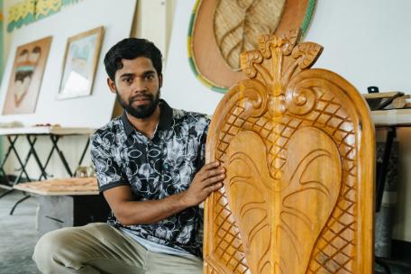 Mohamed Colim, carpintero, con su creación en forma de hoja de taro.