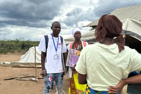 Los promotores de salud de MSF Jorge Francisco Matias y Sinae Mussa hablan con una mujer durante una visita domiciliaria en el campamento de desplazados de Lianda, en el distrito de Mueda.