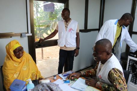 Djibril Ouedraogo, supervisor de enfermería, y sus colegas apoyan a un paciente en el manejo de su enfermedad no transmisible en la sala de tratamiento especializada de Dédougou, Burkina Faso.