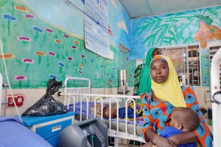 Amina Lawali se sienta junto a su hijo Yusufa mientras se recupera de una malaria grave en el hospital de Gummi, apoyado por MSF