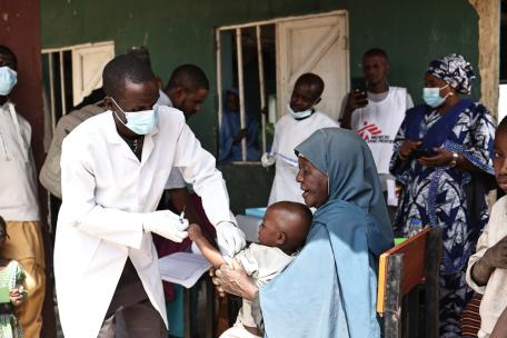 Un niño, sostenido por su cuidador, recibe una dosis de la vacuna contra la difteria en una escuela primaria de la localidad de Durum, en el distrito de Kundun Durum, durante una campaña de vacunación contra la difteria llevada a cabo por el Ministerio de Sanidad del Estado en colaboración con MSF en el estado de Bauchi, al noreste de Nigeria.
