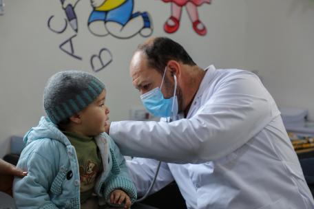 Un médico de la Dirección General de Salud examina a un niño en el centro de atención primaria de Darat Ezza, que cuenta con el apoyo de Médicos Sin Fronteras.  