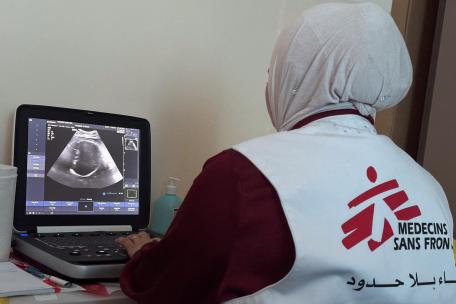 Una trabajadora de MSF revisa la ecografía de un paciente durante una consulta móvil en Khallet Al Mai, Hebrón, Cisjordania.