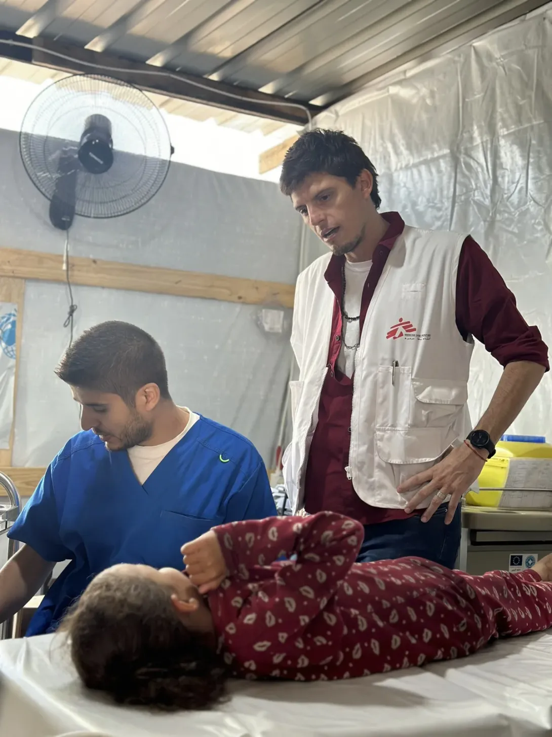 Rúa, de 6 años, herida por una bala que le rozó la cabeza, en la cínica de Médicos Sin Fronteras en Al Mawasi, junto a Paulo Milanesio, coordinador de MSF en Gaza. 
