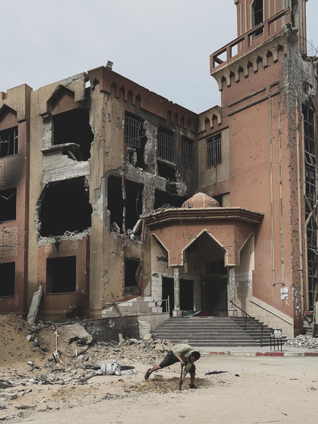 Un hombre gazatí cava un agujero frente a una mezquita en Jan Yunis (sur de la Franja de Gaza), una ciudad difícilmente reconocible tras la retirada de las fuerzas israelíes.