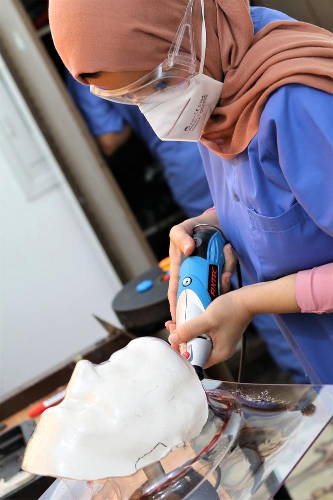 Reem prepara una "máscara facial compresiva" para un paciente con quemaduras en una clínica de Gaza, junio de 2021.