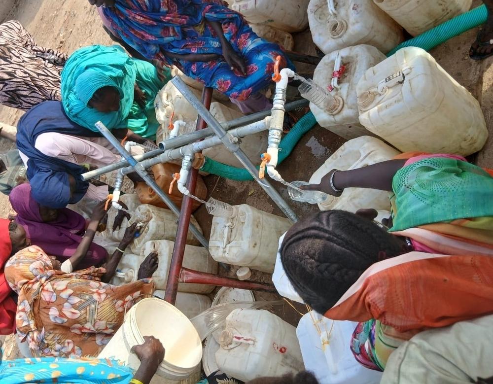 Unas mujeres recogen agua en un punto de distribución de los campamentos de Al Safa.