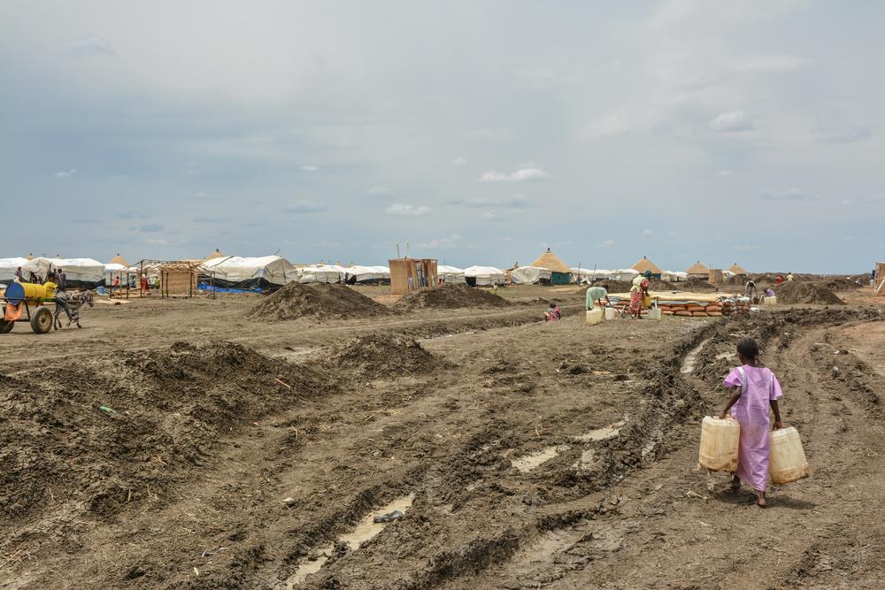 Una niña lleva garrafas para llenarlas en un punto de agua del campo de refugiados de Al-Tanideba, en Sudán.