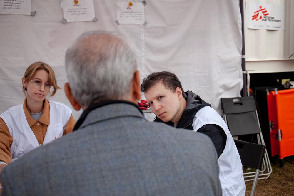 Jad Bitur, mediador cultural y Hanne Beernaerts, enfermera, hablan con un paciente durante una visita en la clínica móvil de MSF en Ter Apel.