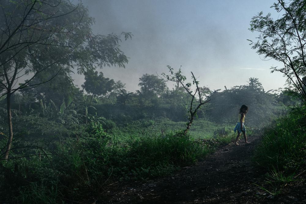 Una niña vuelve a casa andando en Smokey Mountain, Filipinas.