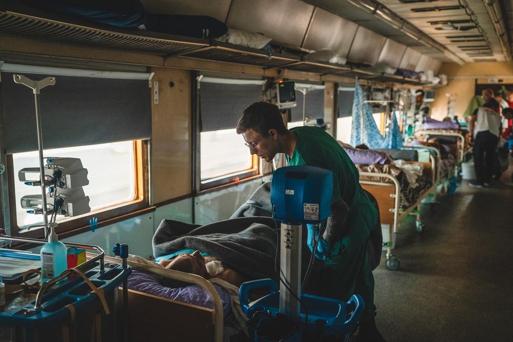 Dmytro Mohylnytskyi, auxiliar de enfermería de MSF monitorea a un herido de guerra en la Unidad de Cuidados Intensivos del tren medicalizado.