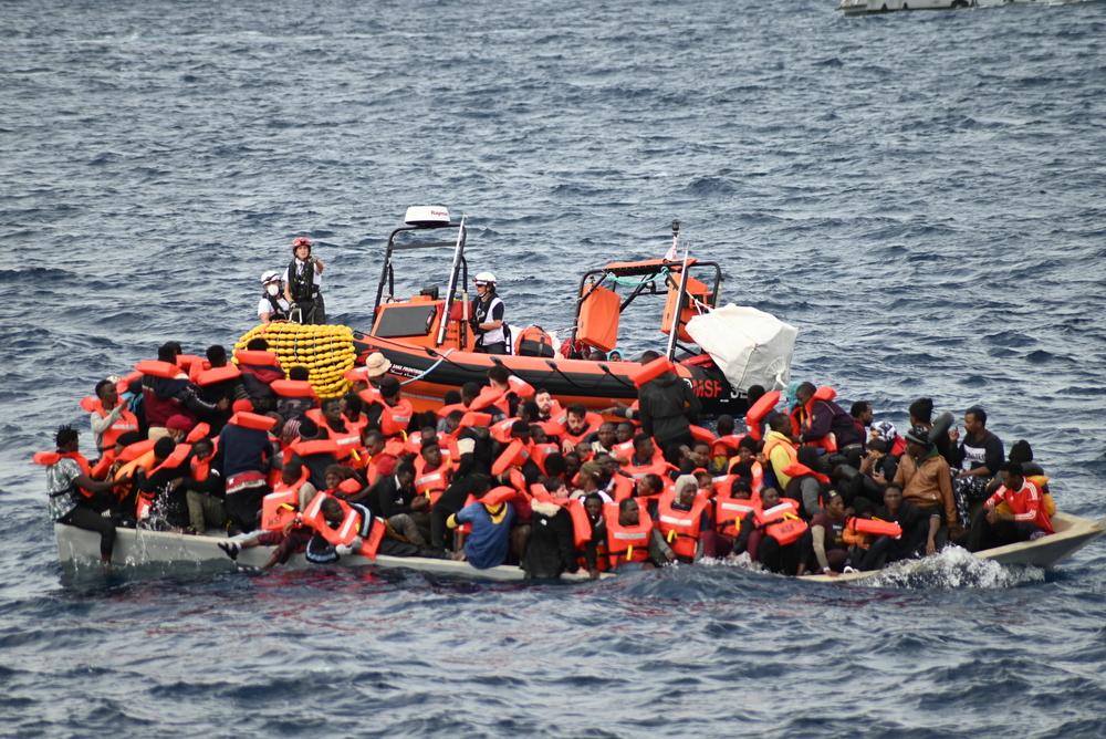 El sobrecargado bote de madera cuando casi todas las personas tienen ya puesto los chalecos salvavidas que facilitan nuestros compañeros.. El sobrecargado bote de madera cuando casi todas las personas tienen ya puesto los chalecos salvavidas que facilitan nuestros compañeros..