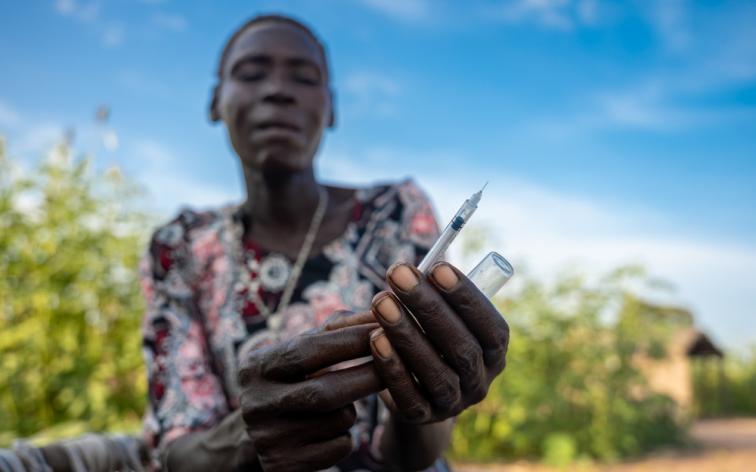 Rebecca muestra cómo utiliza una jeringuilla para administrarle insulina a su hijo Ajou, de 12 años.